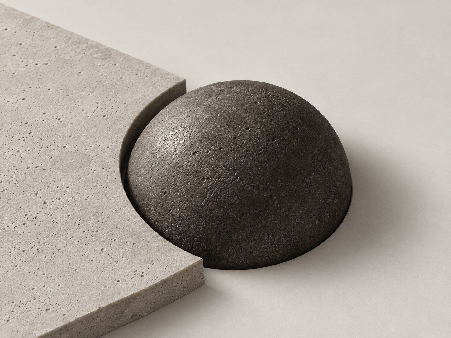 A pale stone slab with its edge cut to the curve of a dark stone dome.